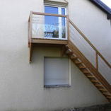 Escalier en mélèze, panneau de verre et câbles acier.