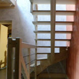 Escalier 1/4 tournant à 1 limon crémaillère avec verrouillage invisible des marches dans le mur latéral.