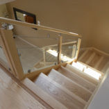 Escalier en frêne olivier, garde-corps avec verre et tubes inox, main-courante ronde sur supports inox.